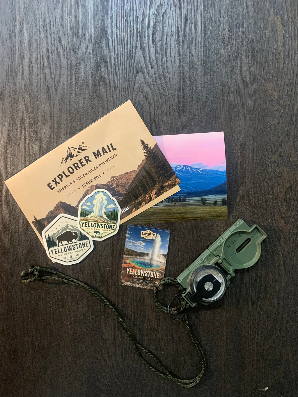 Explorer Mail envelope with Yellowstone vinyl stickers, trading card, and a compass