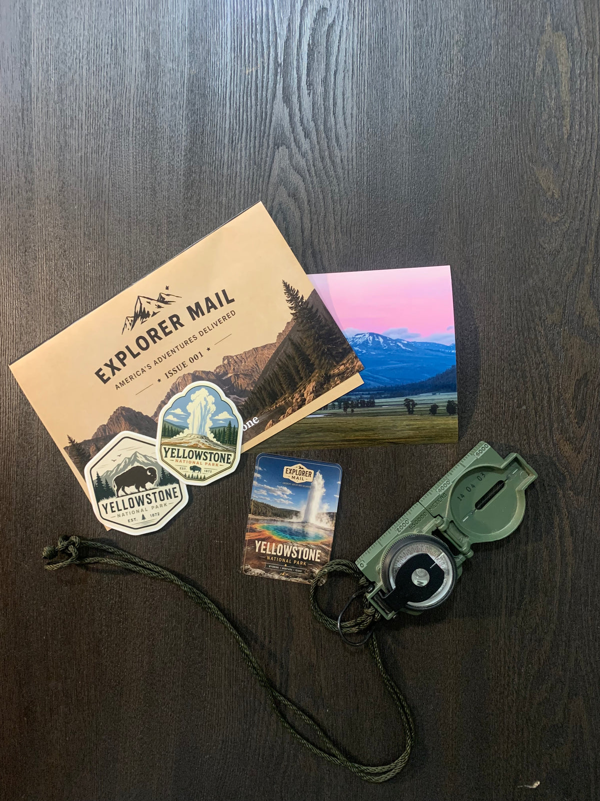 Explorer Mail envelope with Yellowstone vinyl stickers, trading card, and a compass