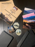 Explorer Mail Yellowstone issue flat lay with printed editorial, photo prints, and vinyl stickers