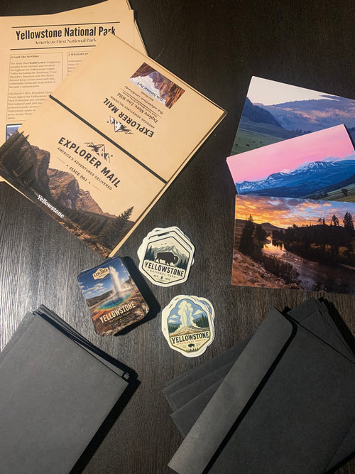Explorer Mail Yellowstone issue flat lay with printed editorial, photo prints, and vinyl stickers
